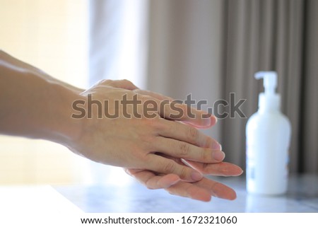 rubbing hands with alcohol gel to kill bacteria and viruses. washing hands with sanitizer to repel the co-vid19 disease. cleaning hands immediately when get back inside the house.  Royalty-Free Stock Photo #1672321060
