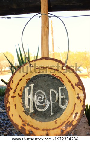 Hanging rusted plate saying hope.