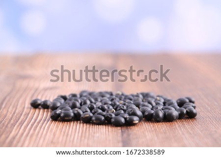 The black beans are on the wooden table
