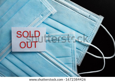 Billboard with the word Sold Out on a pile of masks. All surgical masks are SOLD OUT. Black background