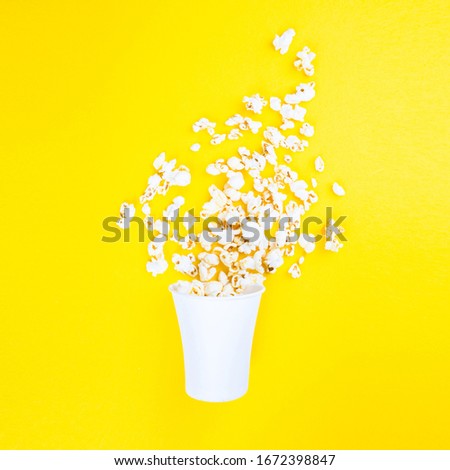 Scattered popcorn on a yellow background. Abstraction and minimalism.
