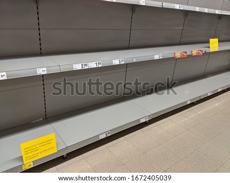 Empty toilet paper shelves in supermarket after panic buying due to outbreaking coronavirus, translation:"There is no stock available due to unpredictable panic buying."