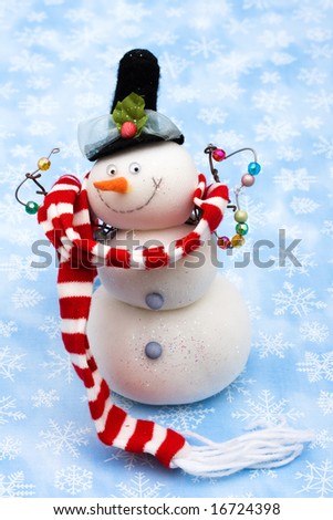 Snowman wearing scarf on blue snowflake background, merry Christmas