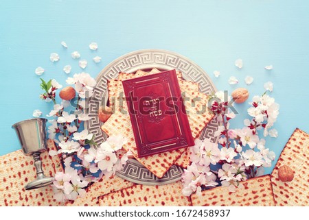 Pesah celebration concept (jewish Passover holiday). Traditional book with text in hebrew: Passover Haggadah (Passover Tale) Royalty-Free Stock Photo #1672458937
