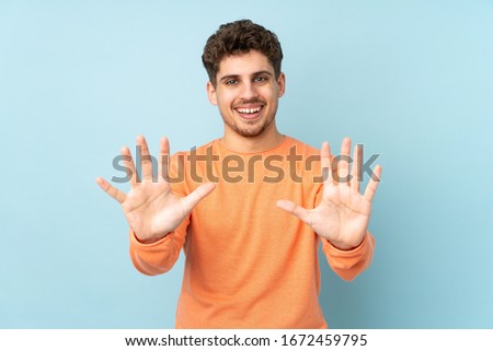 Caucasian man isolated on blue background counting ten with fingers