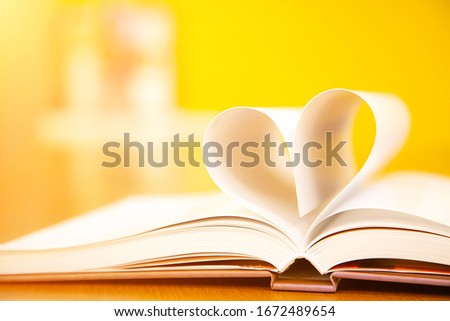 Close up image of a book  in heart shape on the table at library of lifestyle love to read and february valentine day concepts. Royalty-Free Stock Photo #1672489654