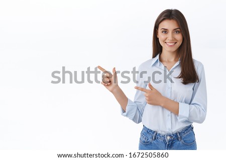 Professional smiling young woman help customer find where go, showing way, pointing finger left and grinning friendly, pleased to answer any questions as introduce new product, white background