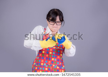 Studio portrait Asian young woman holding house cleaning supplies and floor cleaning on blue background. Housewife are cleaning. House keeping and cleaning concept