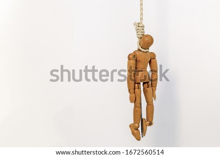 A wooden drawing mannequin hanging from a rope, over white background.