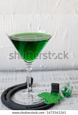 St. Patrick's Day concept. Green drink, green cocktail in a glass, horseshoe and clover leaf