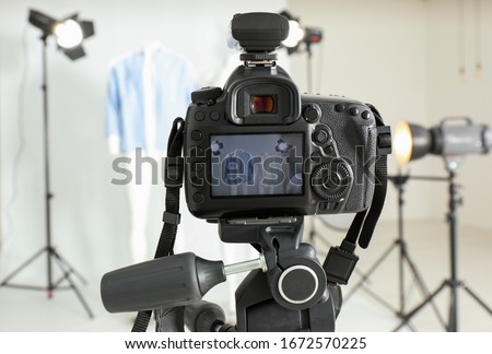 Taking pictures of ghost mannequin with modern clothes in professional photo studio, focus on camera