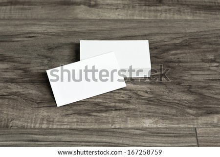Blank corporate identity package business cards on wood floor.