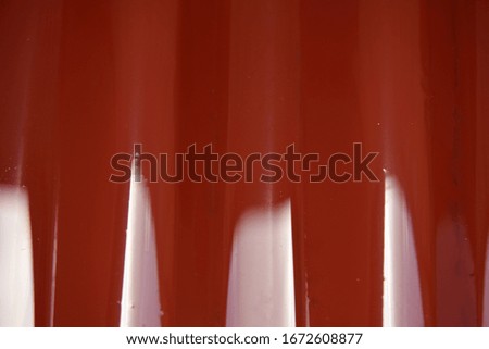 The texture of red metal corrugated sheet and wet skin
