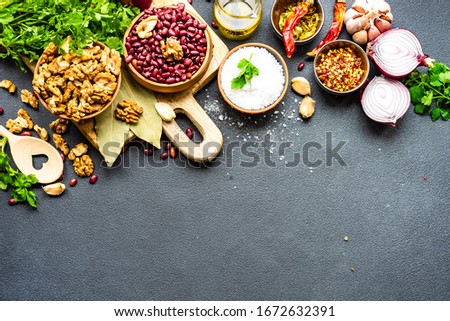 Ingredients for cooking georgian traditional dish lobio with red beans with nuts on rustic background with copy space