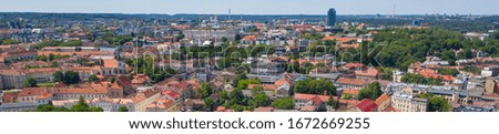 Beautiful panoramic aerial view photo from flying on Gediminas castle in capital Vilnius of Lithuania with Lithuanian flag on the tower and skyline of city center in the background. (series)