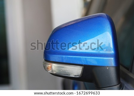 Blue car side mirror and Turn signal light are dirty, good design on the car