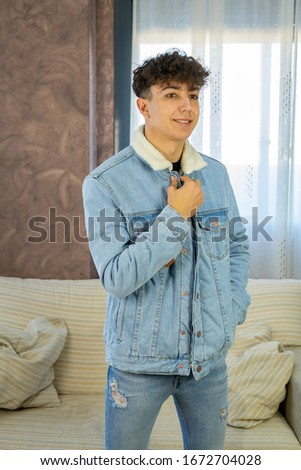Young man posing on a white sofa in his living room