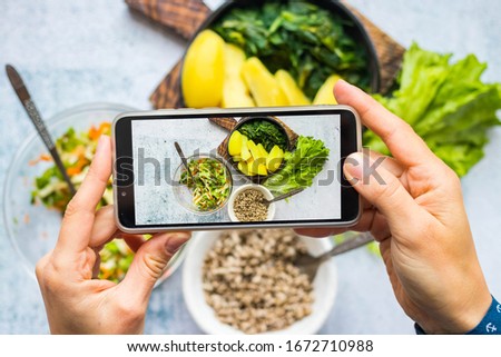 Make phone picture of food. Smartphone photography of vegan, vegetarian lunch, dinner at kitchen, cafe.  Woman hands