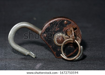 Old padlock with rust but fully functional photographed in the studio                