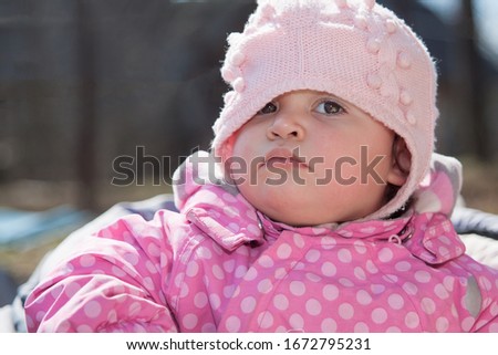 Funny little kid. Little girl with a serious expression. The baby is looking at the camera, a serious face.