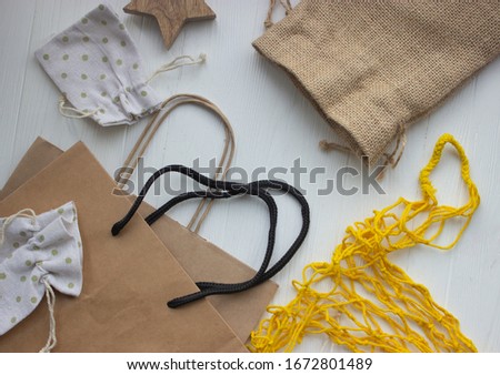 Reusable textile bags and paper bags on wooden background.  Zero waste concept.