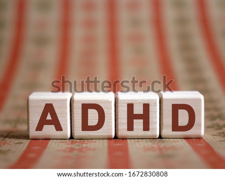 ADHD - medical concept. Attention deficit hyperactivity disorder. Wooden cubes on a color table.