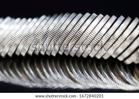 unknown large quantity pile of beautiful old coins with ribbed side, lie together, close-up photo of real metal money illuminated by light