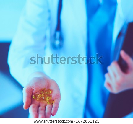 Close-up shot of doctor's hands holding pills.