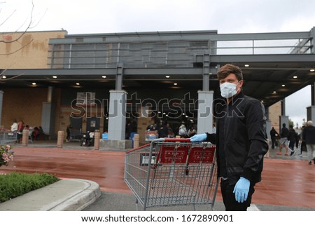 Man wearing face mask, gloves, protection against coronavirus. Covid-19 person. Shopping in USA, America amid corona virus situation Royalty-Free Stock Photo #1672890901