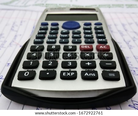 Black button calculator on Physics practical notebook