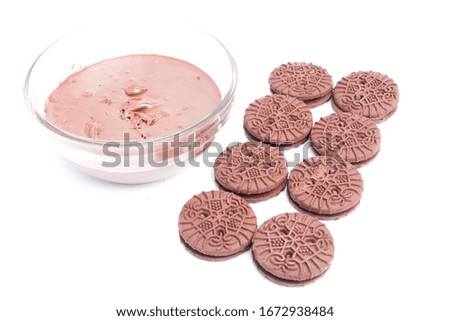 A close up picture of homemade chocolate sandwich biscuits arranged with chocolate spread on isolated white background.