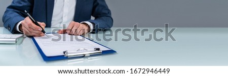 Close-up Of A Person's Hand Signing Contract