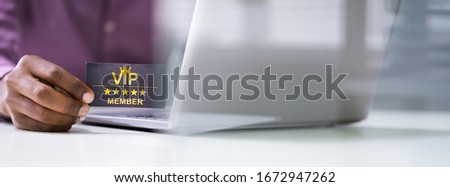 Close-up Of A Person's Hand With Loyalty Card Using Laptop Royalty-Free Stock Photo #1672947262