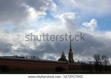 peter and paul fortress in st petersburg under the stormy sky with rays of sun light