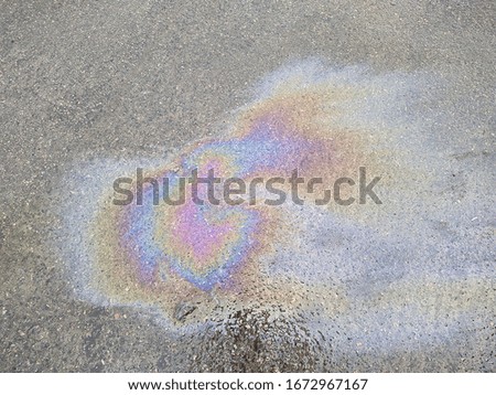 stain of engine and colorful oil on wet pavement in the daytime closeup photo