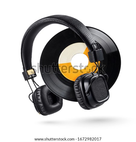 Headphones and wide-hole 7-inch vinyl record isolated on white background 