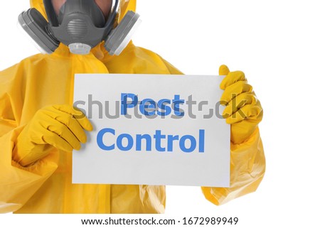 Man wearing protective suit holding sign PEST CONTROL on white background, closeup