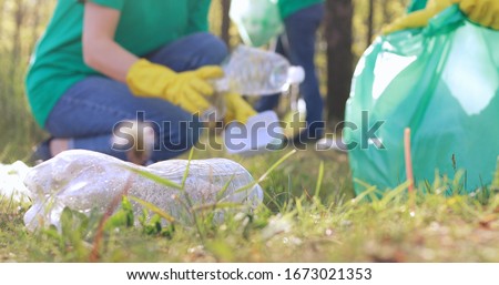 Close up view of plastic on green grass in a public city park, selected by volunteers from nonprofit volunteers. Royalty-Free Stock Photo #1673021353