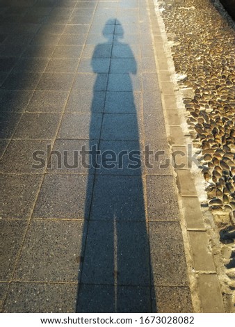 The morning light hit the girl walking on the cement road. The light and reflection images are very beautiful. 