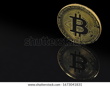 golden bitcoin on black background with reflection and copy space