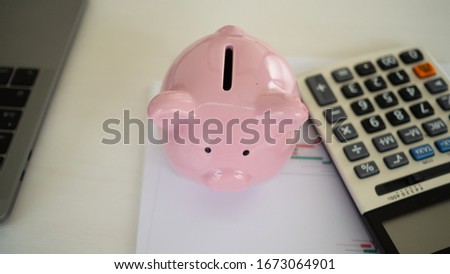 Business woman putting coins in piggy bank. calculator, coins. saving money is an investment for the future. saving money for future concept
