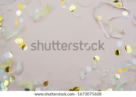 Pink confetti and feathers and sparkles on pink background. Top view, flat lay. Copyspace for text. Bright and festive holiday background. For Easter, New year, Mother's day.