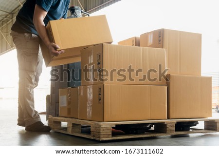 Worker courier lifting package boxes stacking on pallet. Supply chain. warehouse delivery service shipment goods Royalty-Free Stock Photo #1673111602