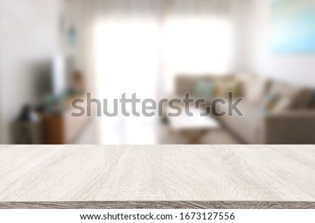 Wooden empty table in front of Living room sofa interior. For product display and presentation Royalty-Free Stock Photo #1673127556