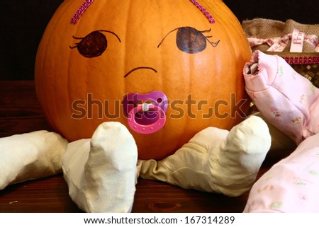 Closeup look at a pumpkin baby with pacifier