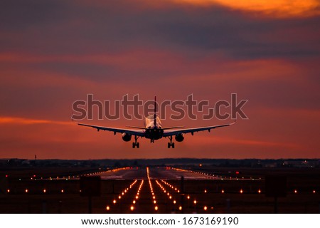 Airplane landing at sunset on otopeni airport Royalty-Free Stock Photo #1673169190