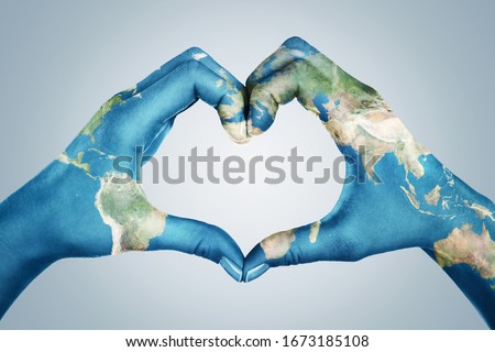 Female hands, painted in the world map,  forming heart shape isolated on blue background Royalty-Free Stock Photo #1673185108