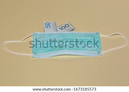 Facial protective mask and Polish zloty banknotes close up isolated on pastel color background, concept of high price of medical product
