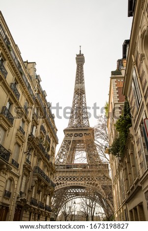 Small paris street with view on the famous paris eiffel tower on a cloudy rainy day. Royalty-Free Stock Photo #1673198827