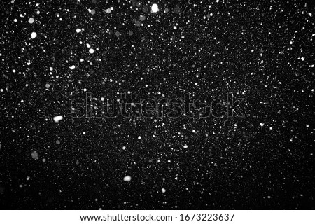 beautiful flying heavy snow on a black background of the night sky